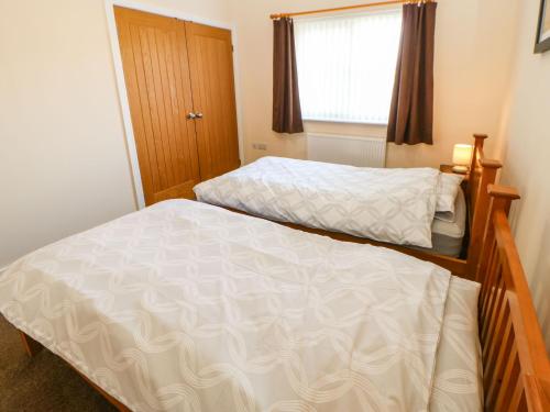 a bedroom with two beds and a window at Coquet in Longframlington