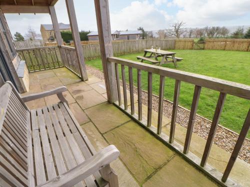 a porch with a bench and a picnic table at Coquet in Longframlington