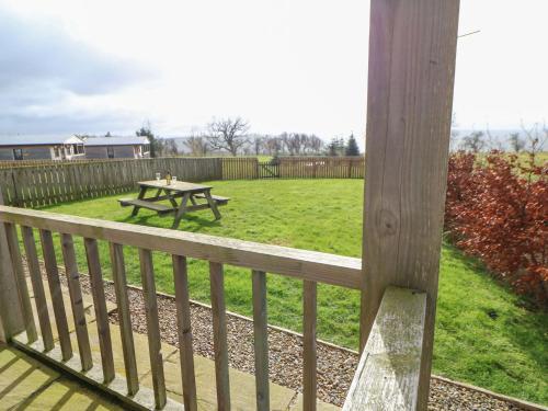 a wooden deck with a picnic table in a yard at Coquet in Longframlington