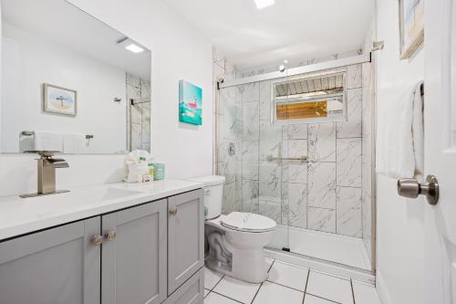 a white bathroom with a shower and a toilet at Casa Cocoanut in Sarasota