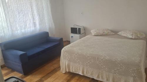 クリチバにあるPousada Félixのベッドルーム1室(ベッド1台、青い椅子付)