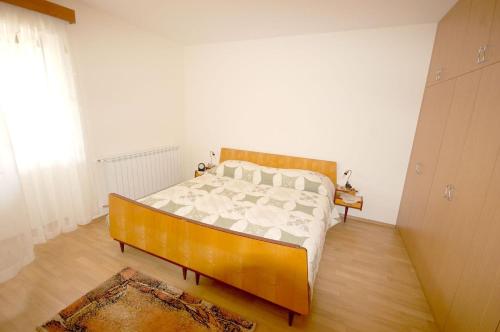 een slaapkamer met een bed in een kamer met een raam bij Family friendly apartments with a swimming pool , Krk - 20500 in Malinska