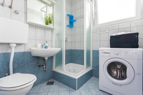 ein Badezimmer mit einer Waschmaschine und einem Waschbecken in der Unterkunft Apartments with a parking space Njivice, Krk - 20504 in Njivice
