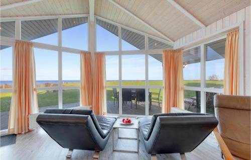 a living room with two chairs and a large window at Strandblick 31 in Schönhagen
