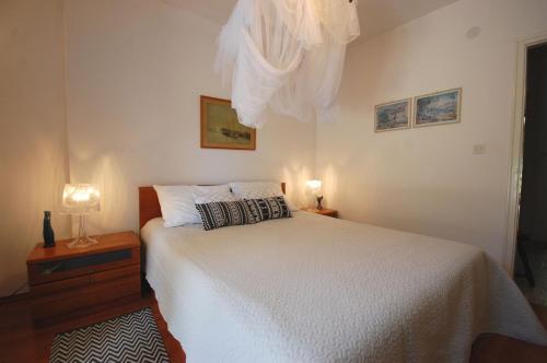 - une chambre avec un lit et une commode avec une lampe dans l'établissement Apartments by the sea Njivice, Krk - 20519, à Njivice