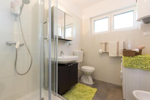 La salle de bains est pourvue d'une douche, d'un lavabo et de toilettes. dans l'établissement Apartments by the sea Njivice, Krk - 20519, à Njivice