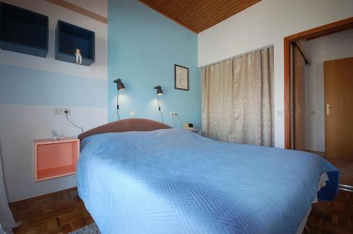 ein blaues Schlafzimmer mit einem Bett in einem Zimmer in der Unterkunft Apartments with parking space Vantacici, Krk - 20507 in Malinska