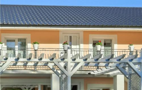 a house with a blue roof with potted plants on the balcony at 1 Bedroom Nice Apartment In Smoldzino in Smołdzino