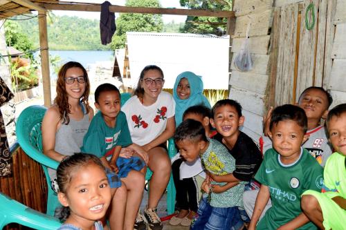 a group of children and adults posing for a picture at Tanjung Kalemo Resort in Batudaka