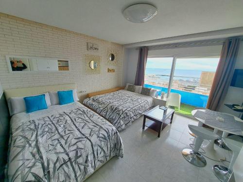 a bedroom with two beds and a view of the ocean at Mirador 22 in Alicante