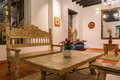Habitación con banco de madera y jarrón sobre una mesa en La Xalca Hotel - Asociado Casa Andina, en Chachapoyas