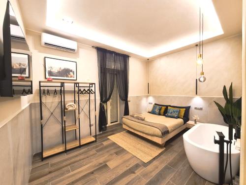 uma casa de banho com uma banheira, uma cama e um sofá em Falco Suite Apartment em Nápoles