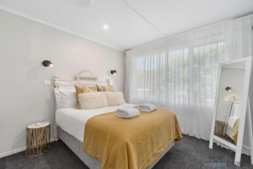 Un pat sau paturi într-o cameră la La Petite Maison - Taupo