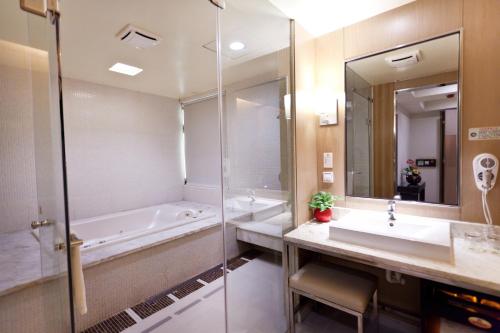 a bathroom with a tub and a sink and a shower at 168 Motel-Hsinchu in Hsinchu City