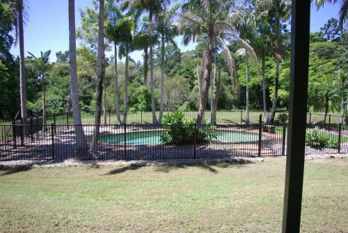 a fence with a pool in a park with palm trees at The Bushranger Hideaway in Midginbil