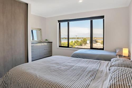 1 dormitorio con 2 camas y ventana grande en Bridport by the Sea, en Bridport