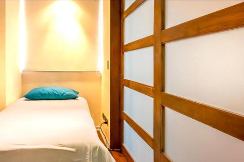 1 dormitorio con 1 cama y puerta corredera de cristal en San Ignacio Suite Apartments, en Santiago