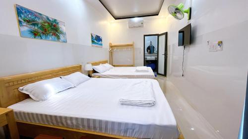 2 Betten in einem kleinen Zimmer mit einem TV in der Unterkunft Bảo Phúc Bungalow- Đảo Phú Quý in Cu Lao Thu