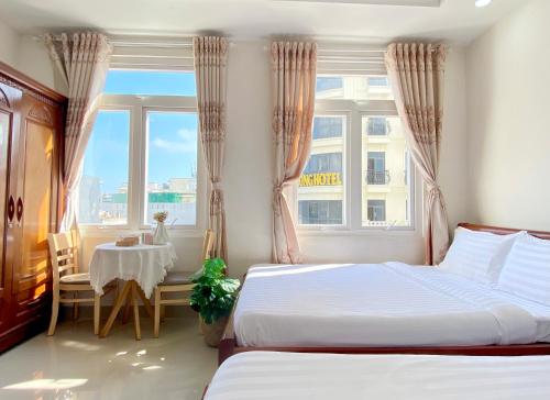 um quarto com 2 camas, uma mesa e uma janela em Shiny Homestay Da Nang em Da Nang