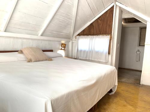 a bedroom with two white beds and a window at Villa Polinesia Chamela in Pérula