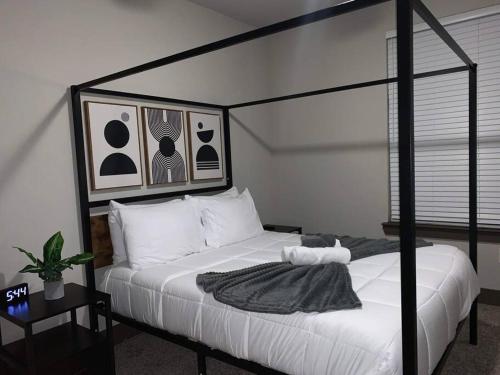 - une chambre avec un lit à baldaquin noir et des oreillers blancs dans l'établissement Business District Double Master w/ Pool!, à Houston
