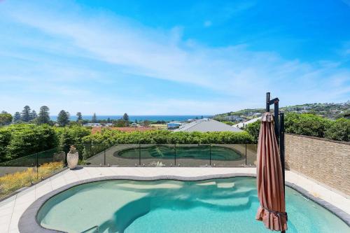 a swimming pool with an umbrella and an umbrella at Sapphire on Wilson Gerringong in Gerringong