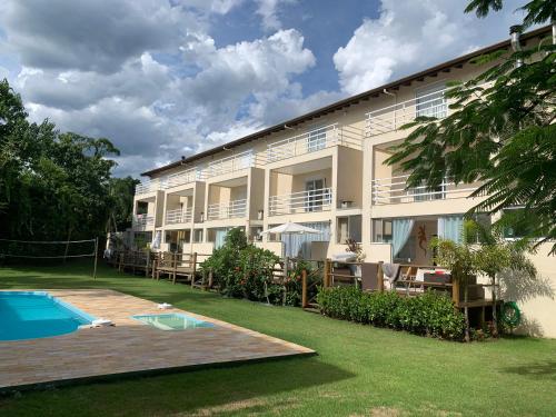 a building with a swimming pool and a resort at Linda Casa em Camburizinho 100 m da praia in São Sebastião