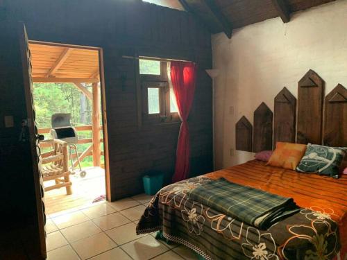 a bedroom with a bed and a door to a patio at Cabaña Romantica Odette en Zona Boscosa con WiFi in Mazamitla