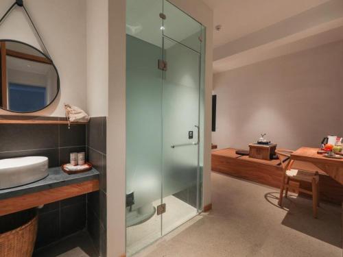 a bathroom with a glass shower and a sink at Villa EN Emerald Valley, Huangshan in Huangshan Scenic Area