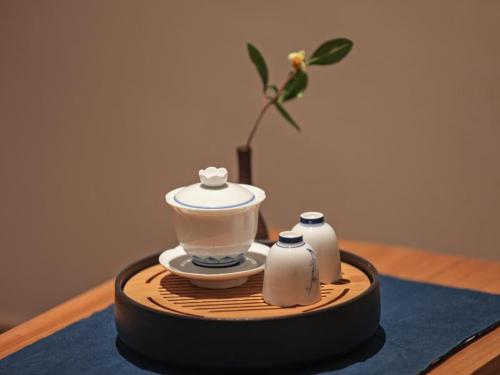 a wooden tray with a tea pot and two bottles at Villa EN Emerald Valley, Huangshan in Huangshan Scenic Area