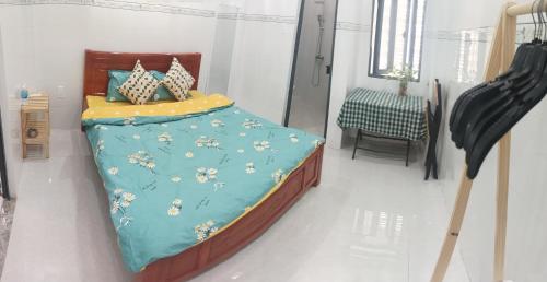 a bedroom with a bed with a blue comforter at Căn Hộ 3 PN Rin's House in Phan Thiet