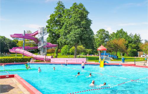 a group of people in a swimming pool with a water slide at 2 Bedroom Lovely Home In Heinkenszand in Heinkensand