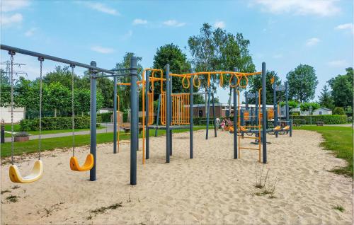 a playground with a slide and a swing set at 2 Bedroom Lovely Home In Heinkenszand in Heinkensand