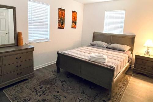 1 dormitorio con cama, tocador y espejo en Misha’s Hunn Cottage, en Yuba City