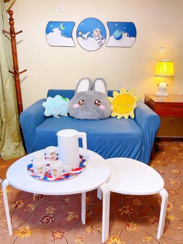 a room with a blue couch and a table with a toy at King Parkview Hotel in Beijing