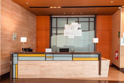 a lobby with a reception desk in a building at Holiday Inn Guayaquil Airport by IHG in Guayaquil