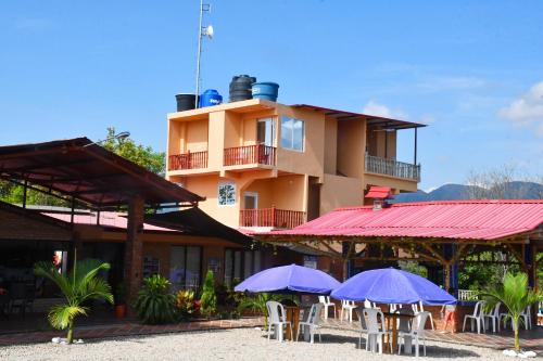 a building with tables and purple umbrellas in front of it at BONANZA in Monterrey