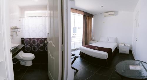 ピウラにあるLM Hotelesのベッドとトイレ付きの小さな部屋です。