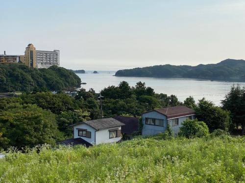 eine Gruppe von Häusern auf einem Hügel mit dem Wasser in der Unterkunft Hotel Ryokan Togenkyo - Vacation STAY 97146v in Ise