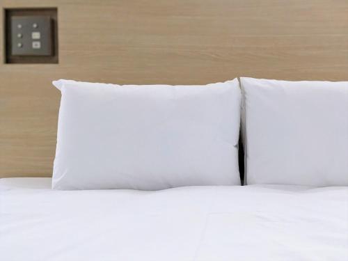a group of white pillows sitting on top of a bed at SOKI Kanazawa in Kanazawa