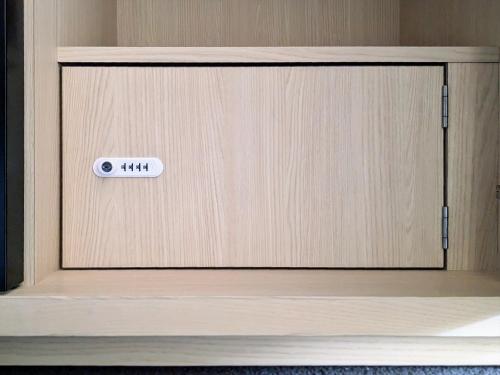 a wooden cabinet with a door with a sign on it at SOKI Kanazawa in Kanazawa