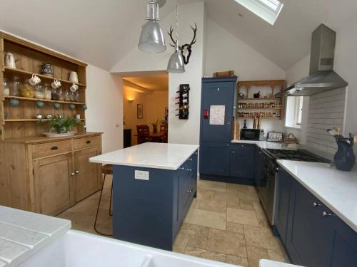 - une cuisine avec des armoires bleues et un réfrigérateur bleu dans l'établissement Country Cottage Retreat-With Hot Tub & Firepit/BBQ, à Kingston