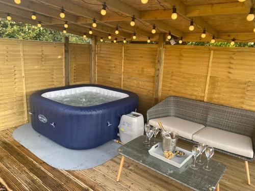 a sauna with a large blue tub and a table at Country Cottage Retreat-With Hot Tub & Firepit/BBQ in Kingston