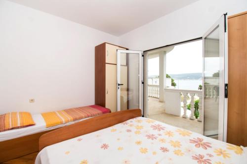 a bedroom with a bed and a balcony at Apartments More Sunce in Seline