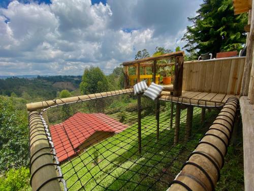 une cage pour oiseaux assise au-dessus d'une clôture dans l'établissement Bio Cabaña Maria Guadalupe, à Rionegro