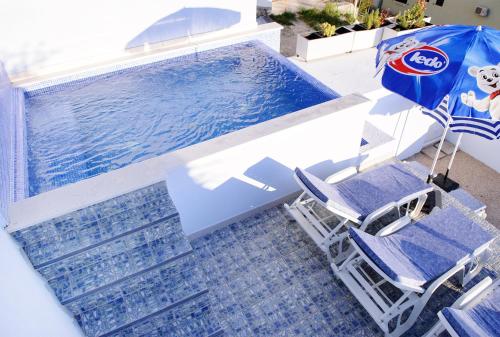two chairs and an umbrella next to a swimming pool at Villa Palloma in Baška Voda
