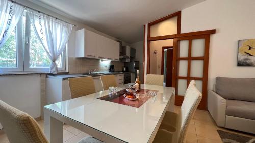 a kitchen and dining room with a white table and chairs at House Roca in Vodice