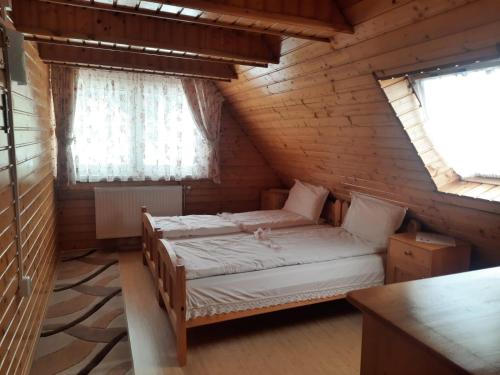 2 Betten in einem Zimmer mit 2 Fenstern in der Unterkunft Antal Villa - 5mins to ski slope & 1min to skating in Harghita-Băi