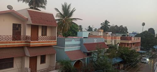 a group of houses with red roofs and palm trees at Uthamar Illam in Tiruchchirāppalli