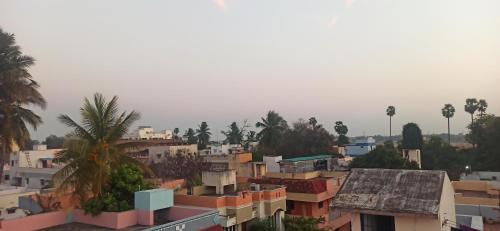 a view of a city with buildings and palm trees at Uthamar Illam in Tiruchchirāppalli